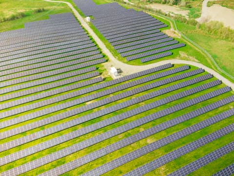 Aerial view of a large solar farm in a green landscape